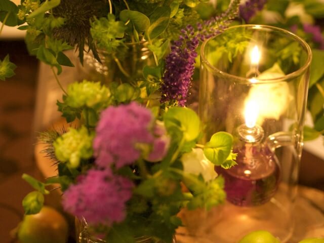 テーブル花と共に置かれた煌めくキャンドル