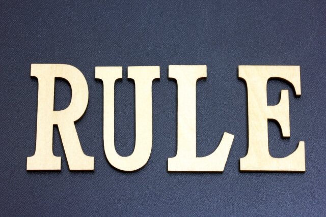 インディゴカラーの布地の上に置かれたシルバーに光る「RULE」の大文字