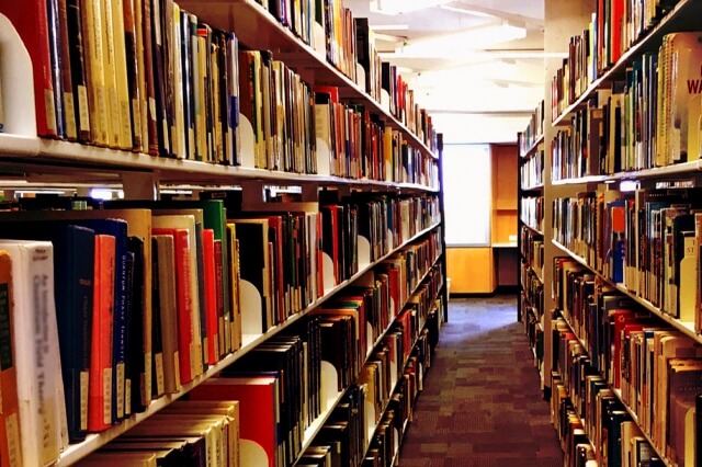 価値の高そうな蔵書を多数並べた書架を持つ落ち着きのある図書室