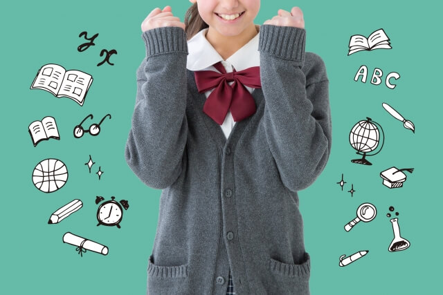 教科書，文具及び教具等のイラストに囲まれた制服のセーターを着た女子学生