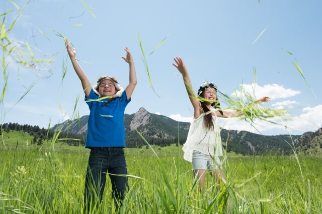 草原で遊ぶ女の子と男の子（提供，photoAC）