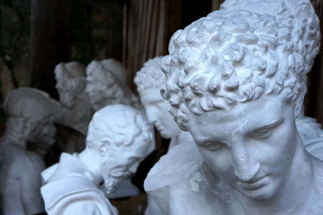 古代ローマの哲学者を想起させる白い石の彫像群