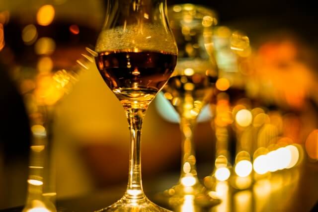 スタイリッシュなワイングラスが薄暗い微光の中に一列に並んで浮かんでいる。